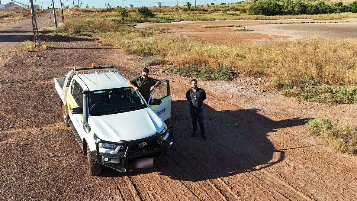 Parsa Ardestani and Jordan Ala'i standing beside a ute on red pindan ground in the Kimberley
